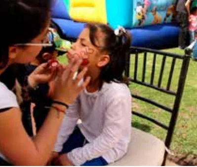 Niña con la cara pintada y figuras de globos